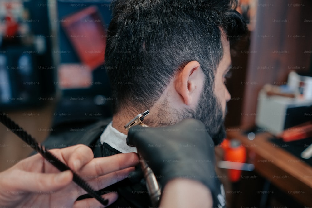 um homem cortando o cabelo por um cabeleireiro