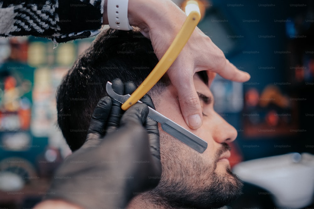um homem cortando o cabelo de outro homem com uma tesoura