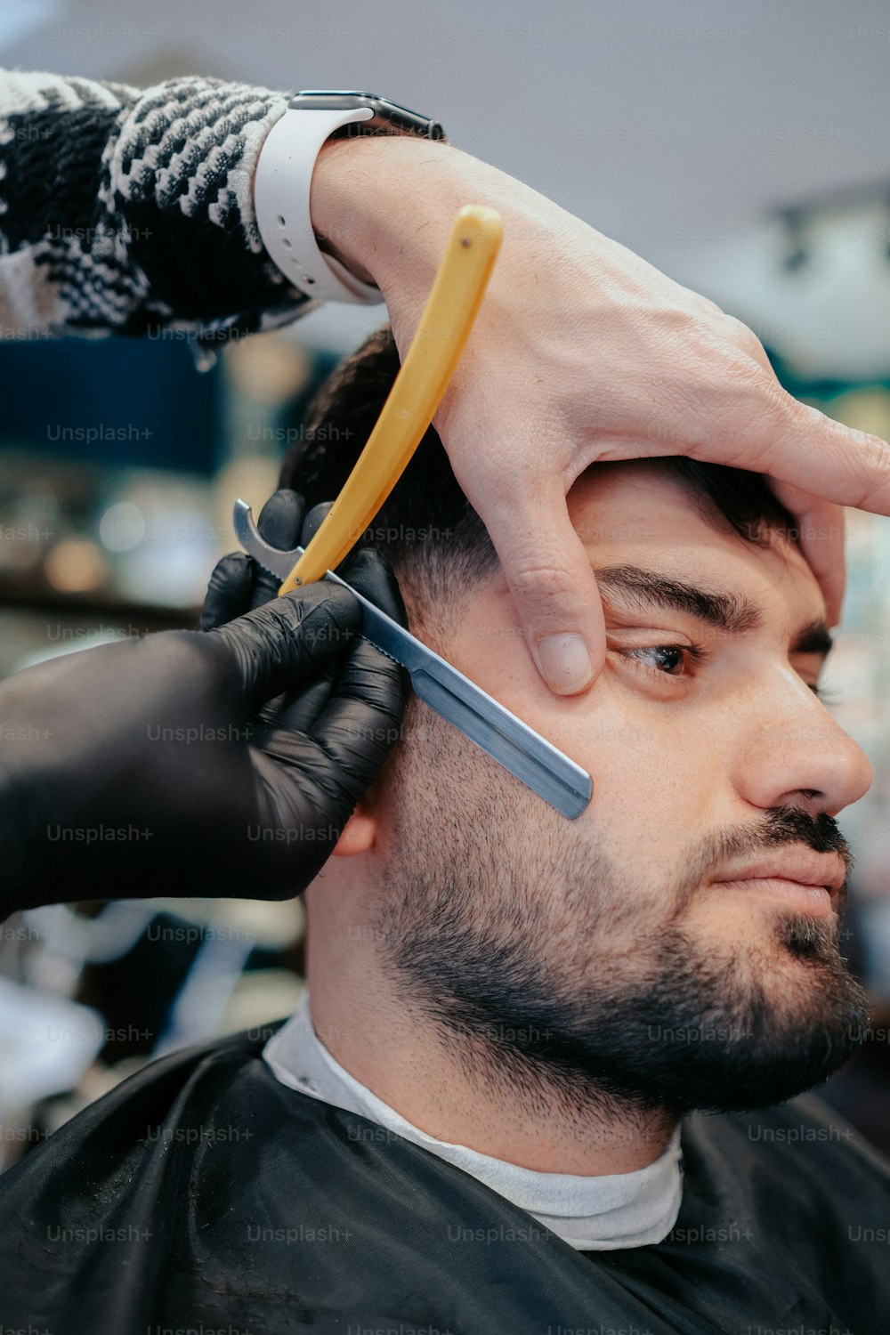 a man cutting another mans hair with a pair of scissors