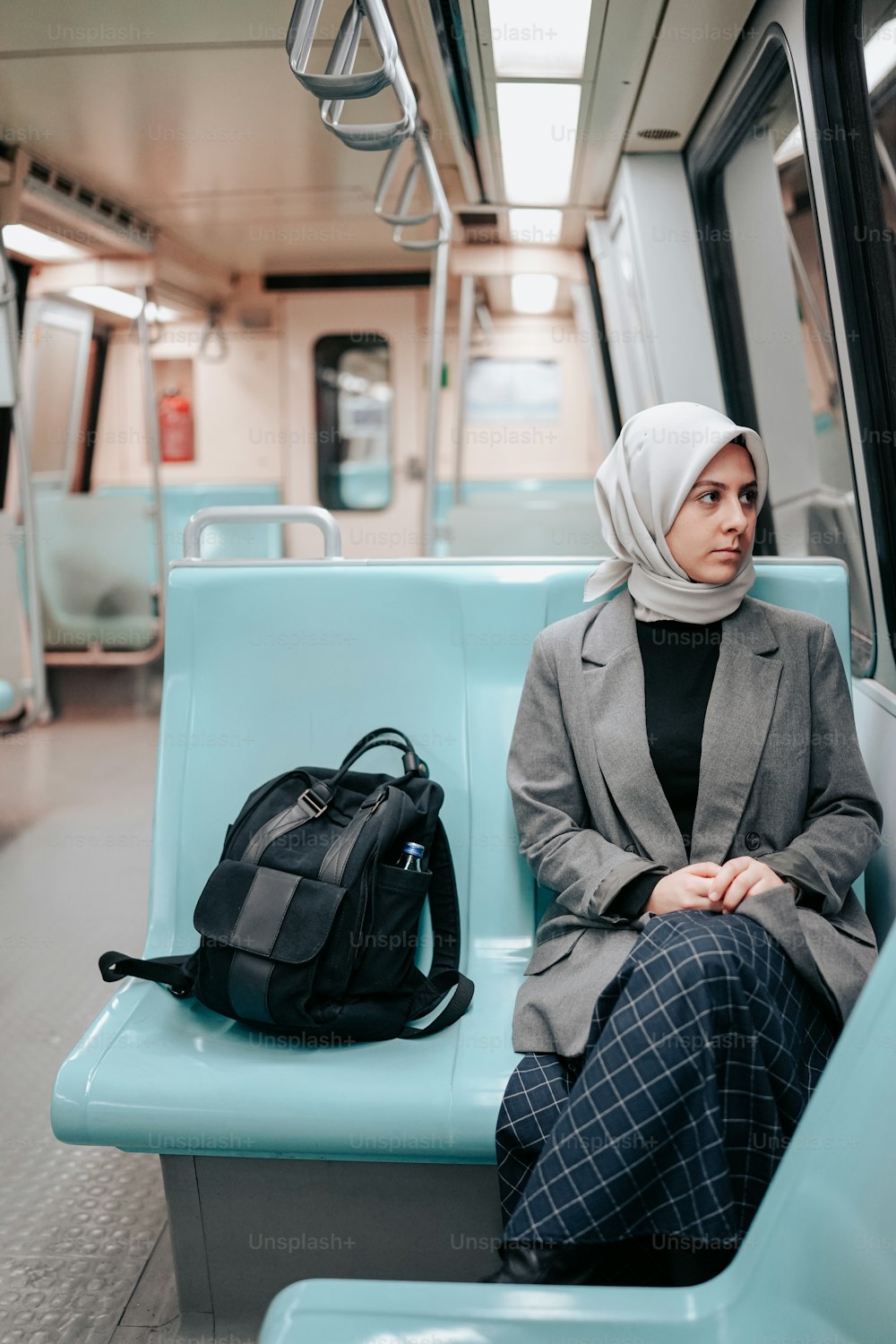 a woman sitting on a train with a backpack