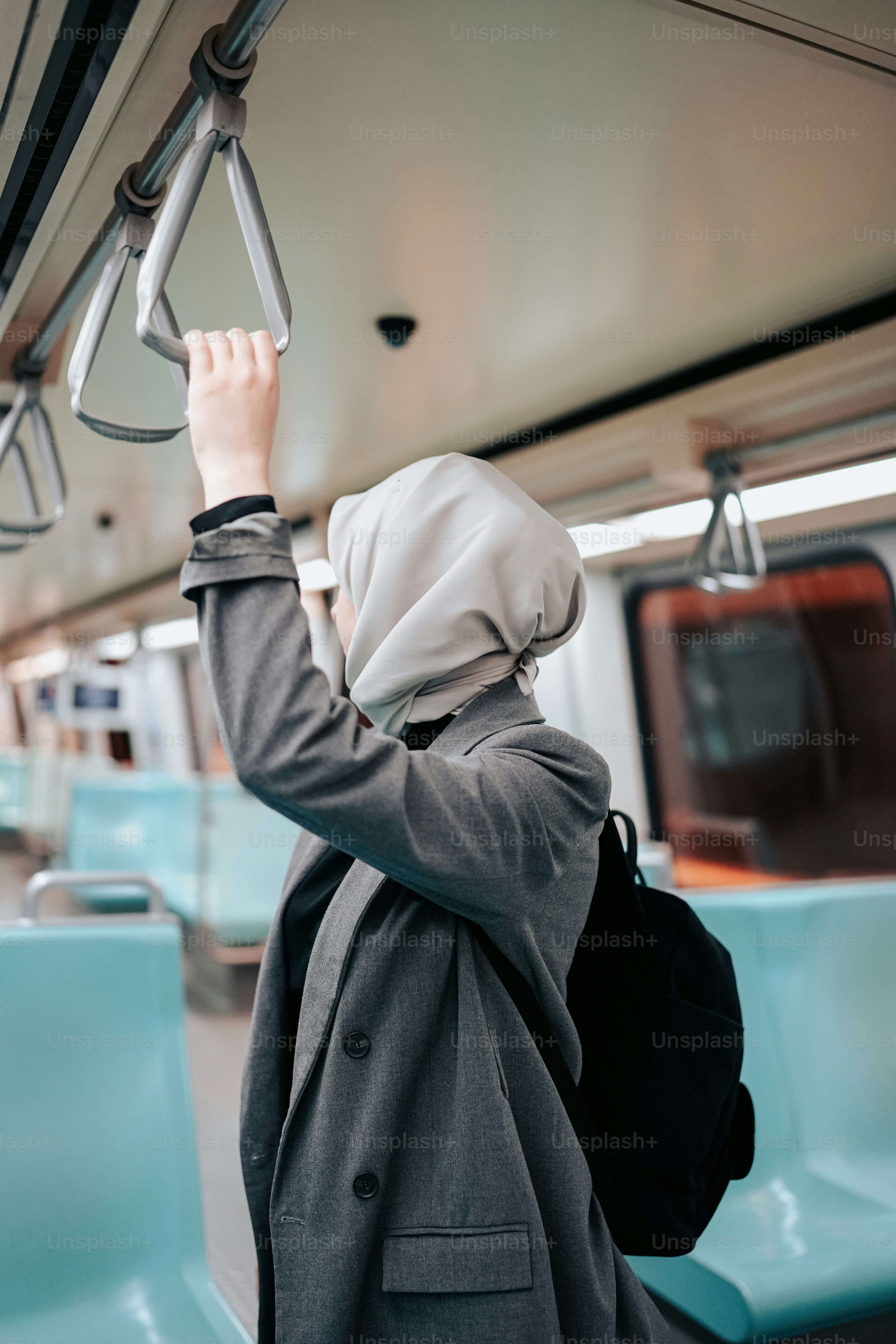 a woman in a hijab is on a train