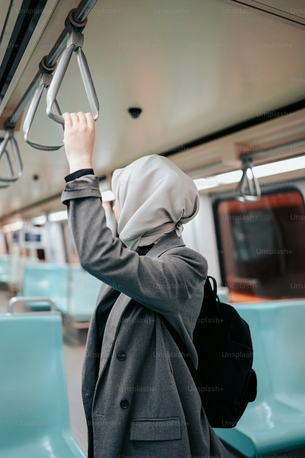 a woman in a hijab is on a train