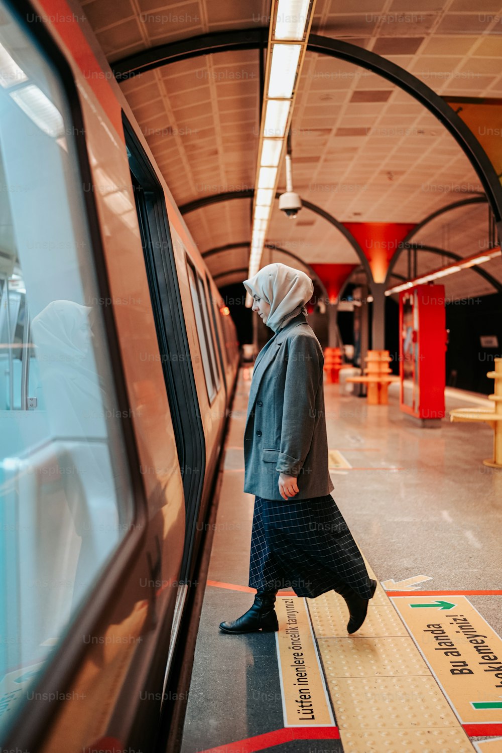 a woman in a hijab is waiting for a train