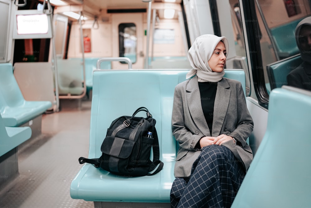 Eine Frau sitzt mit Rucksack im Zug
