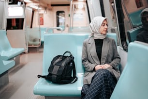 a woman sitting on a train with a backpack