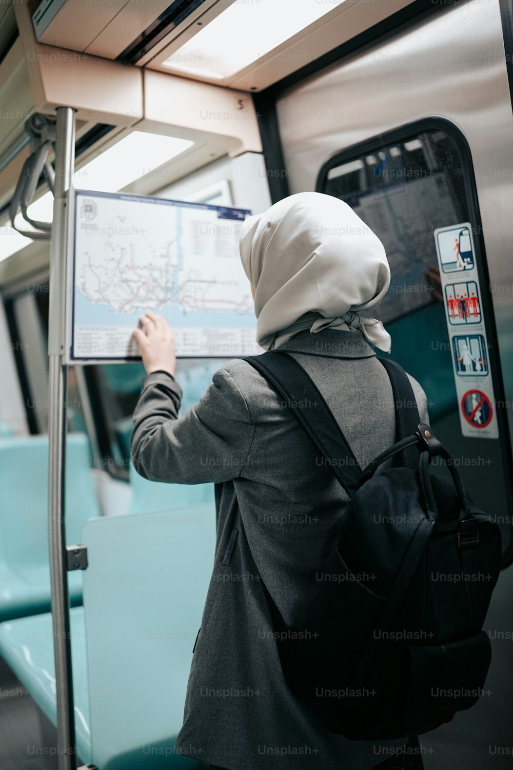 a woman in a hijab is looking at a map