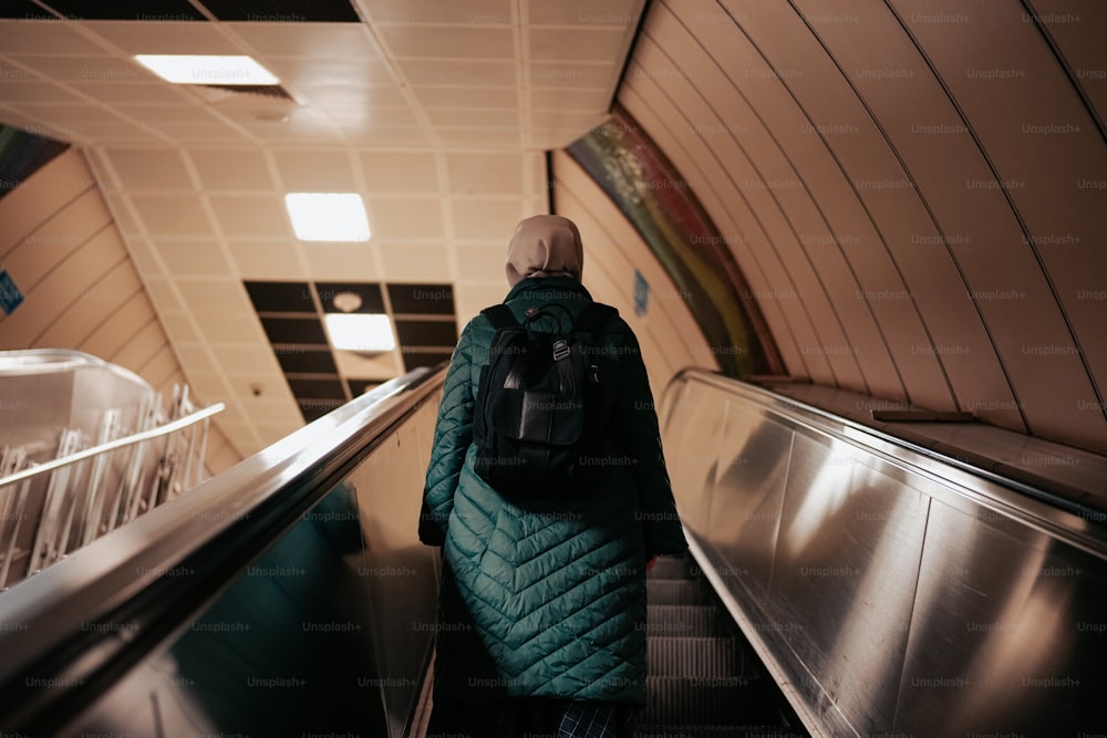 a person with a backpack riding an escalator