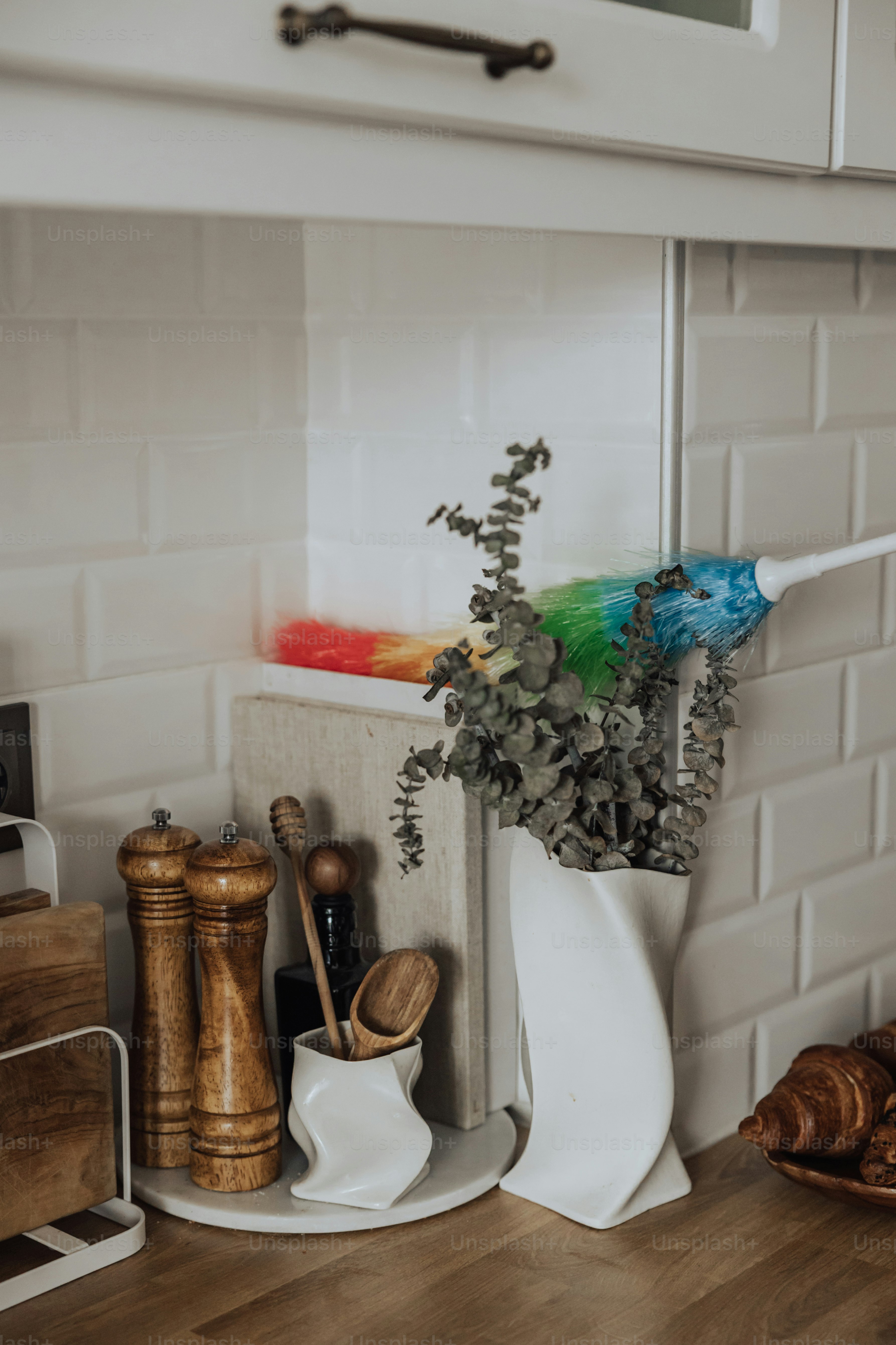a kitchen counter with a white vase filled with flowers
