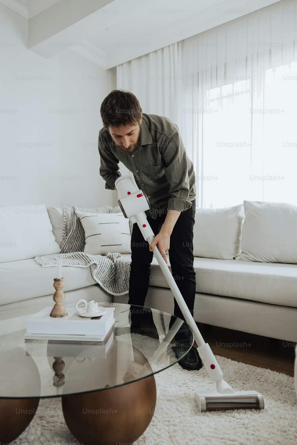 Ein Mann putzt ein Wohnzimmer mit einem Wischmopp