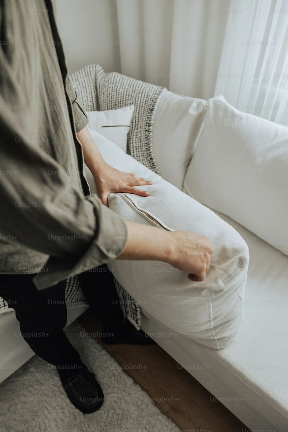 a person holding a knife and fork over a white couch