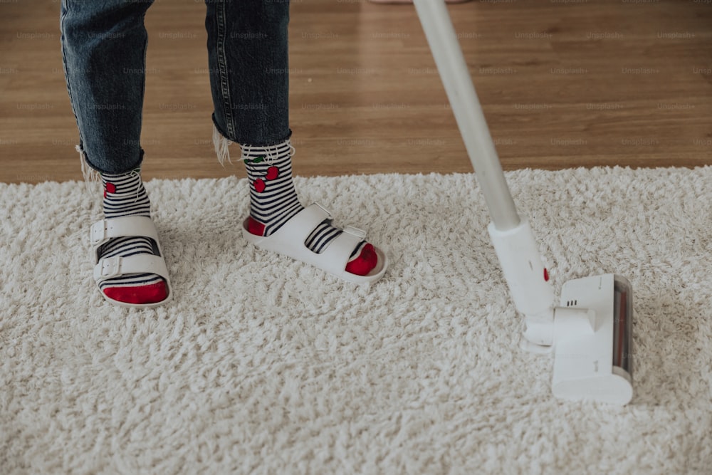 a person standing on a carpet with a mop