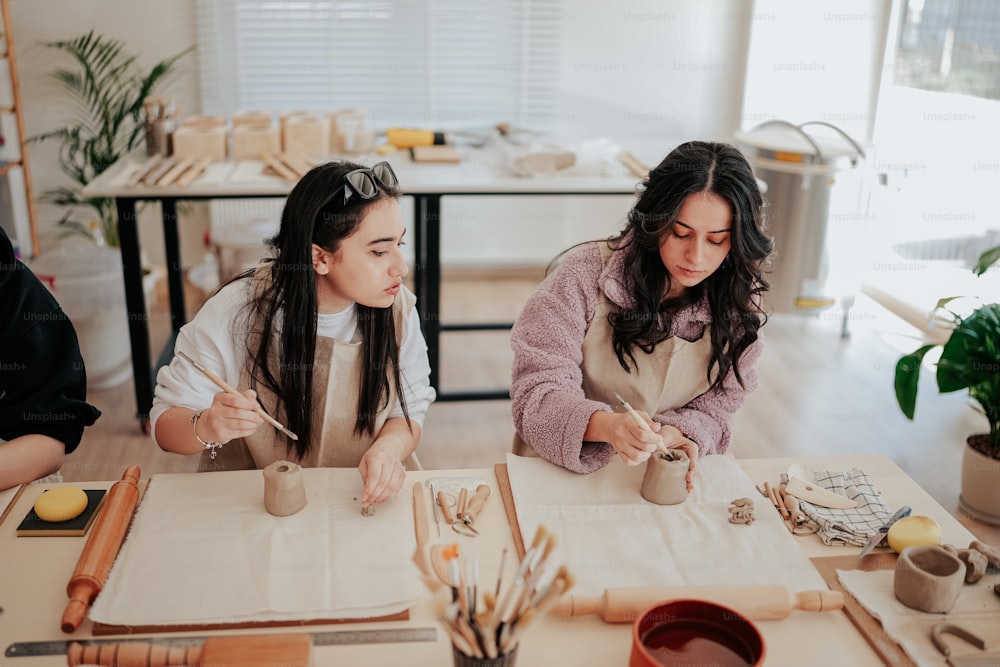Zwei Frauen sitzen an einem Tisch und arbeiten am Handwerk