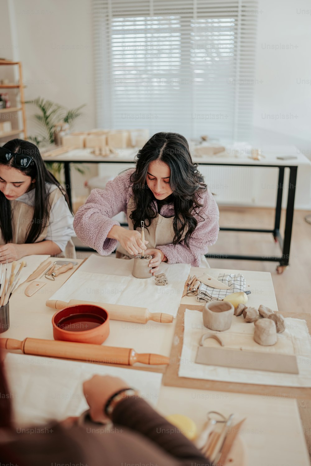 Un gruppo di donne sedute a un tavolo che lavorano sulla ceramica