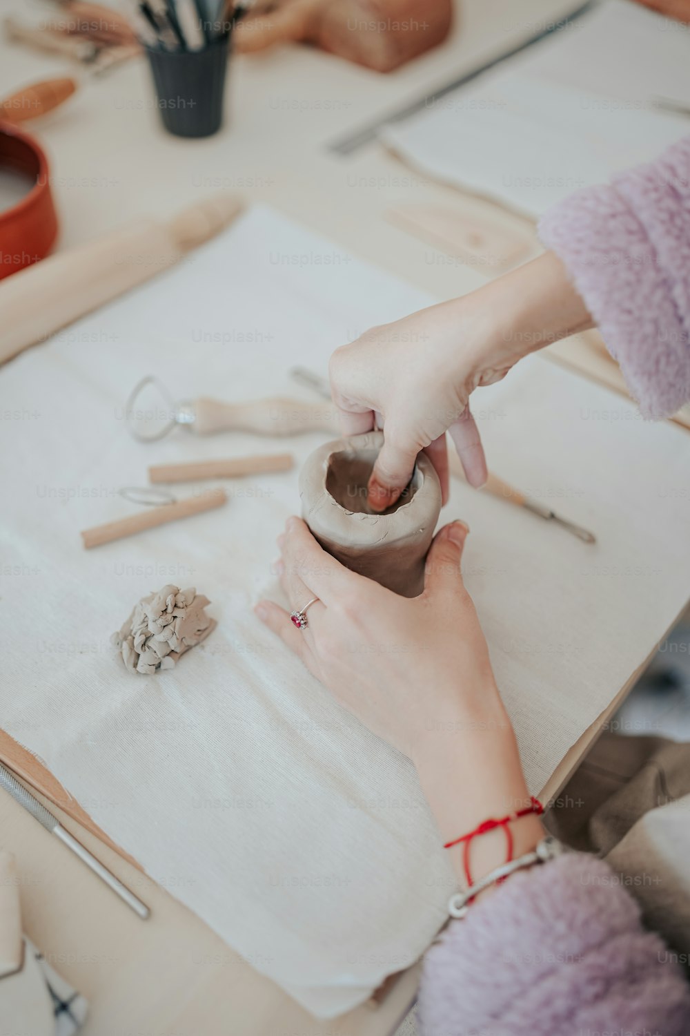 女性が粘土で花瓶を作っている
