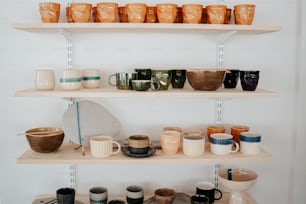 a couple of shelves filled with lots of cups