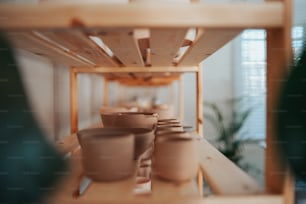 a row of vases sitting on top of a wooden shelf