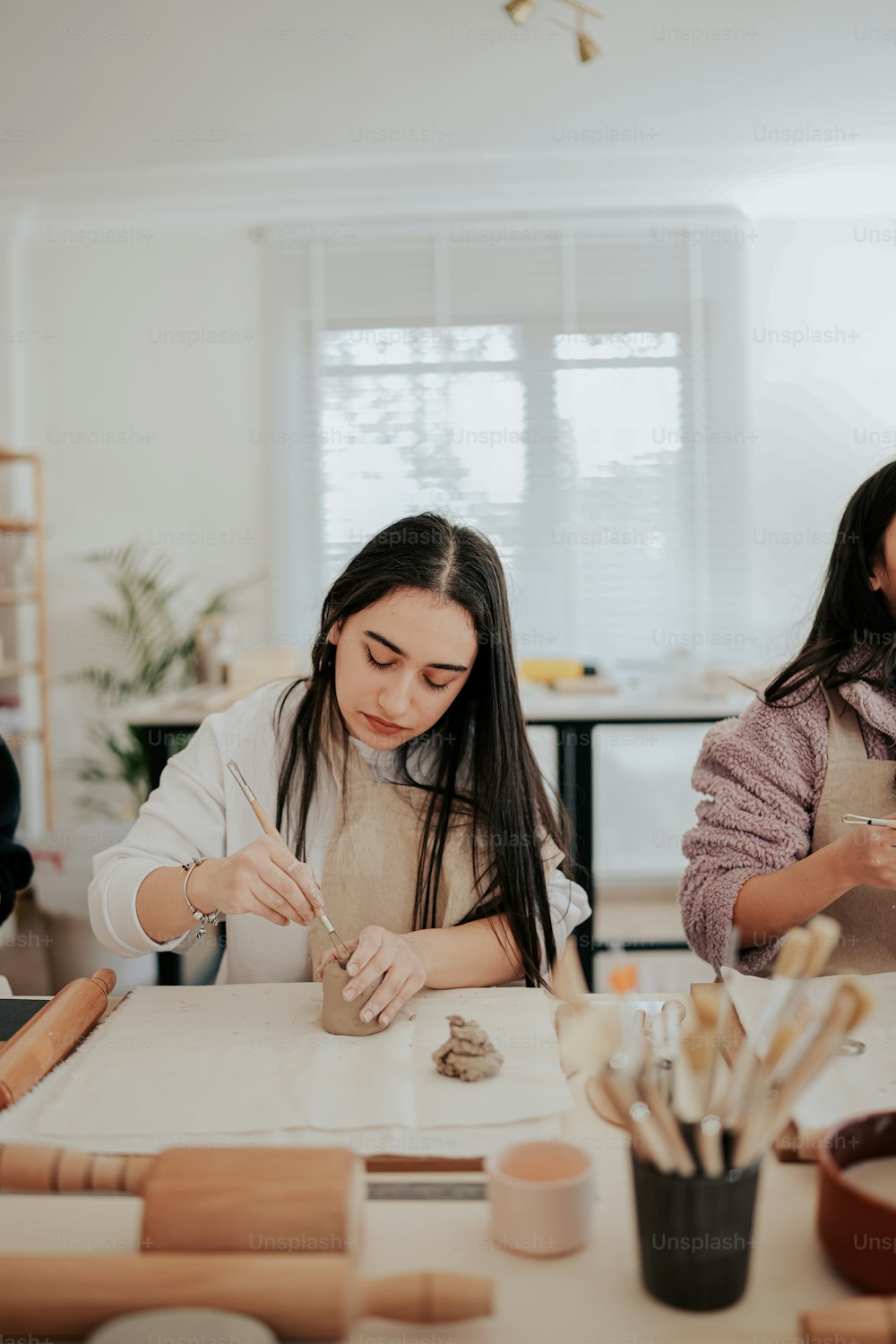 Dos mujeres sentadas en una mesa trabajando en manualidades