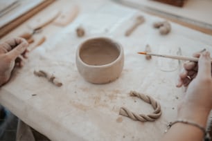 a person is making a bowl out of clay
