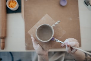 a person holding a cup with a spoon in it