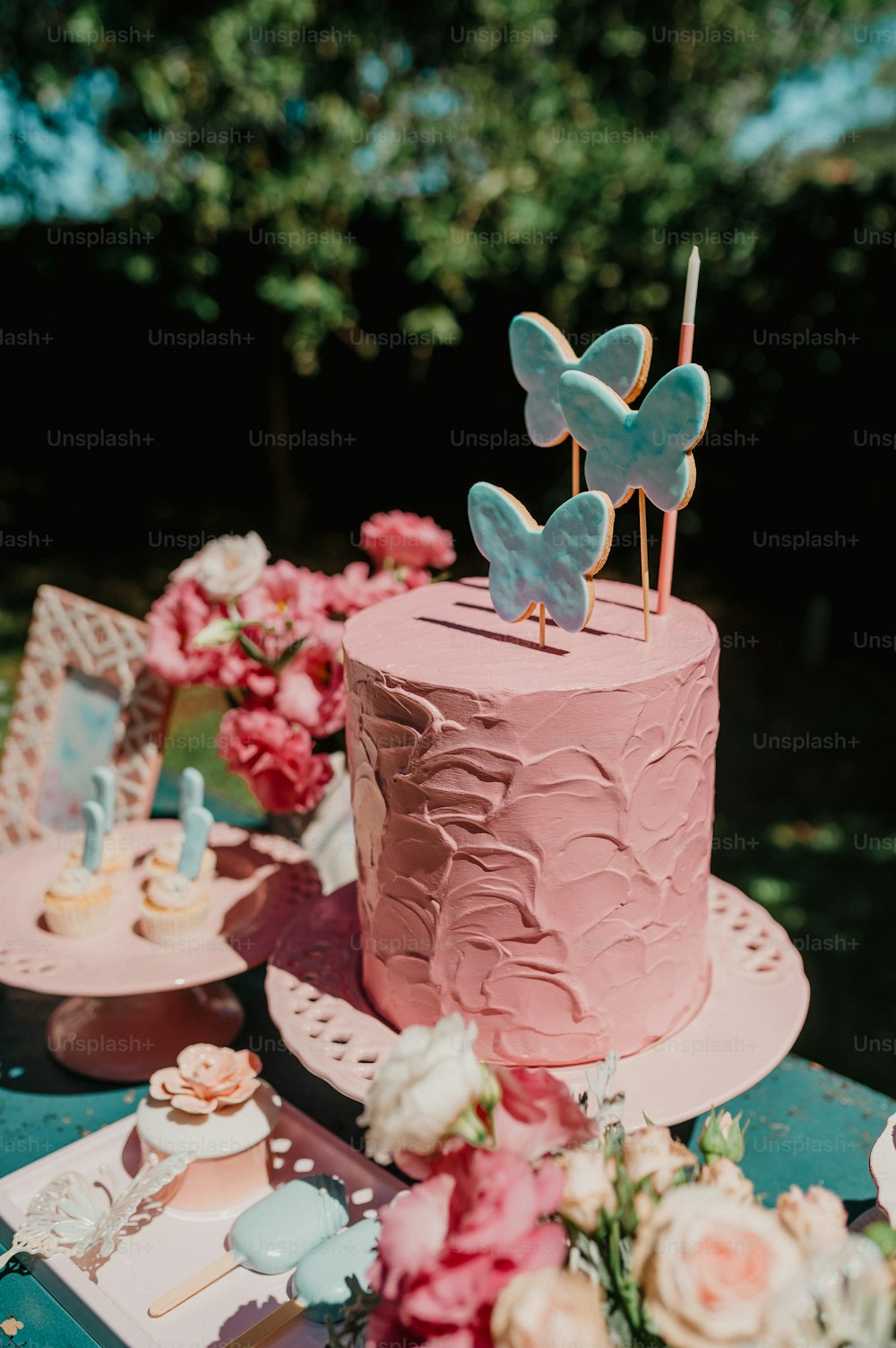a pink cake sitting on top of a table