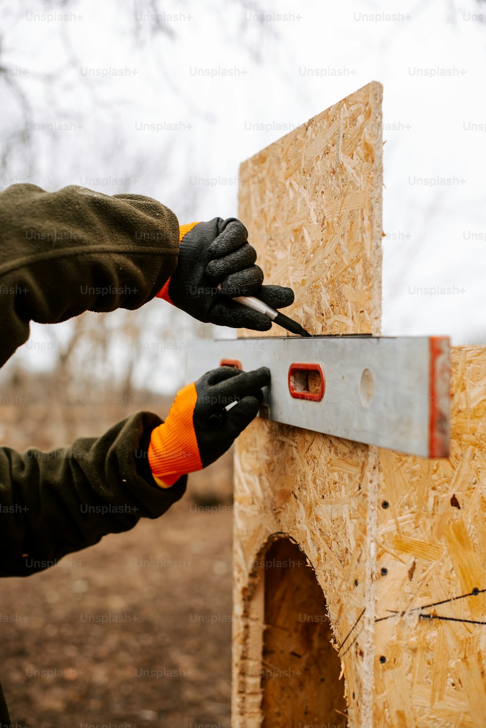 Una persona con un par de tijeras cortando un trozo de madera