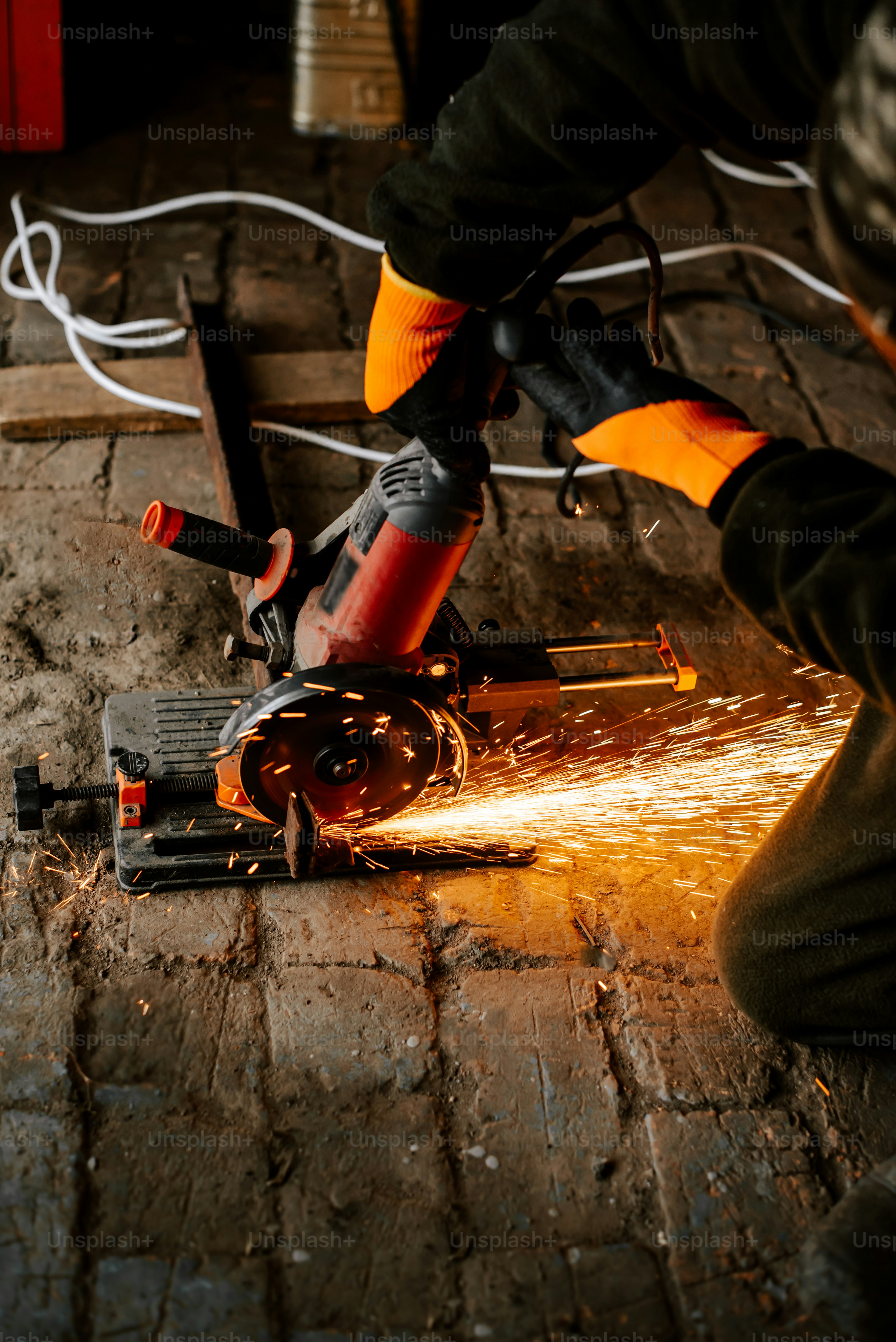 a person cutting a piece of metal with a grinder