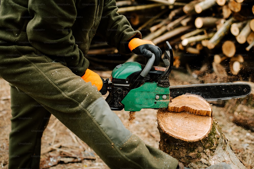 a person using a chainsaw to cut a log