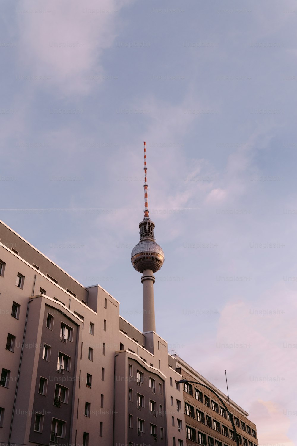 Ein hohes Gebäude mit einem Fernsehturm im Hintergrund