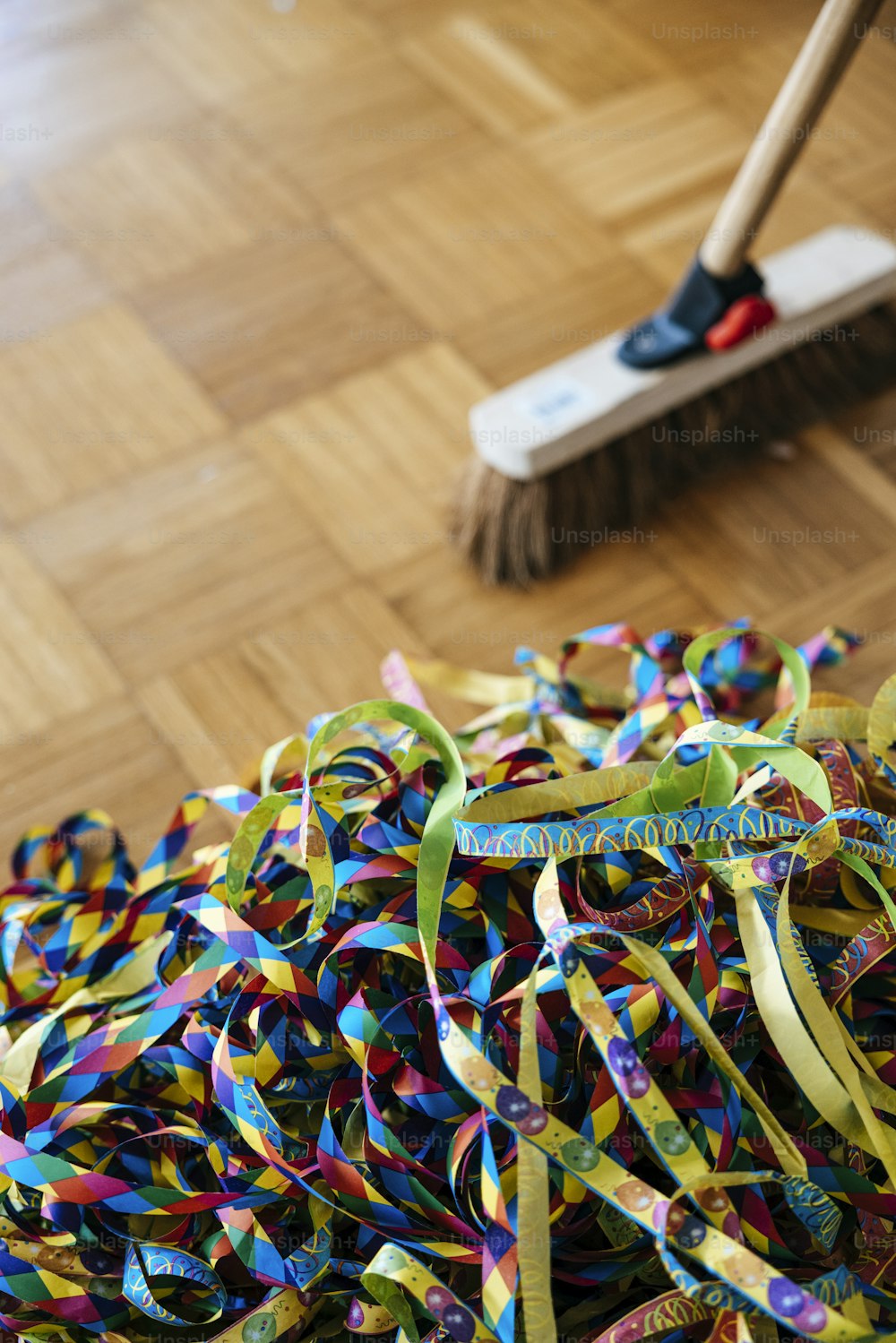 a broom and a pile of streamers on a hard wood floor