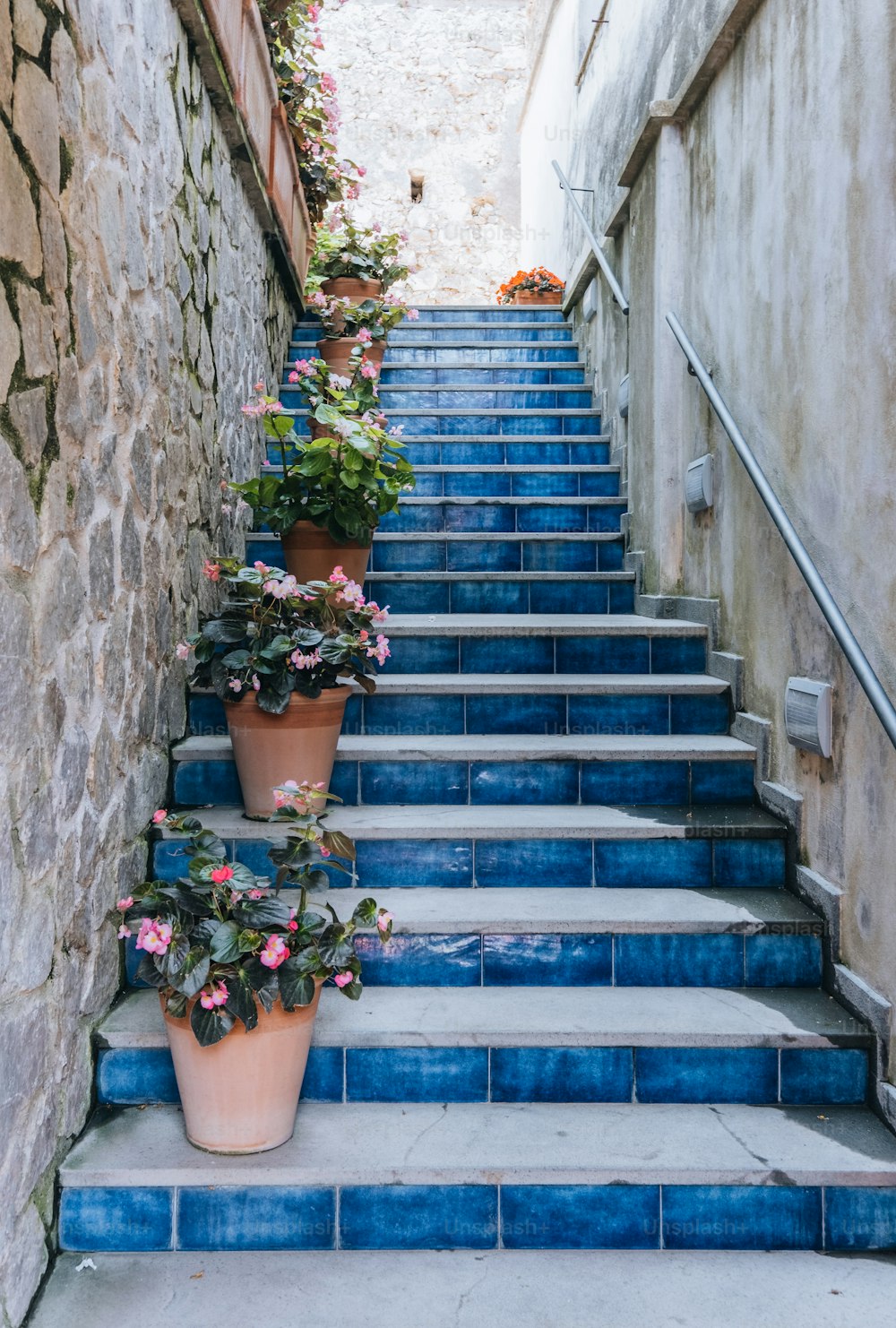 a set of blue stairs with potted plants