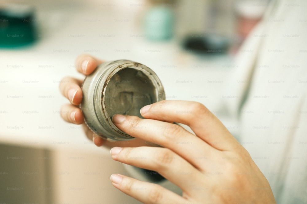 a person holding a jar in their hand