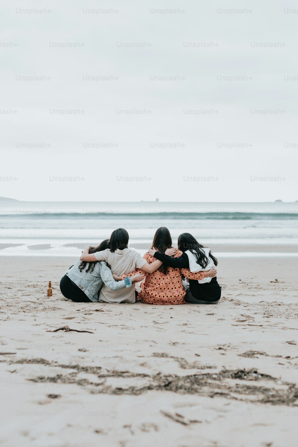 um grupo de pessoas sentadas em cima de uma praia de areia