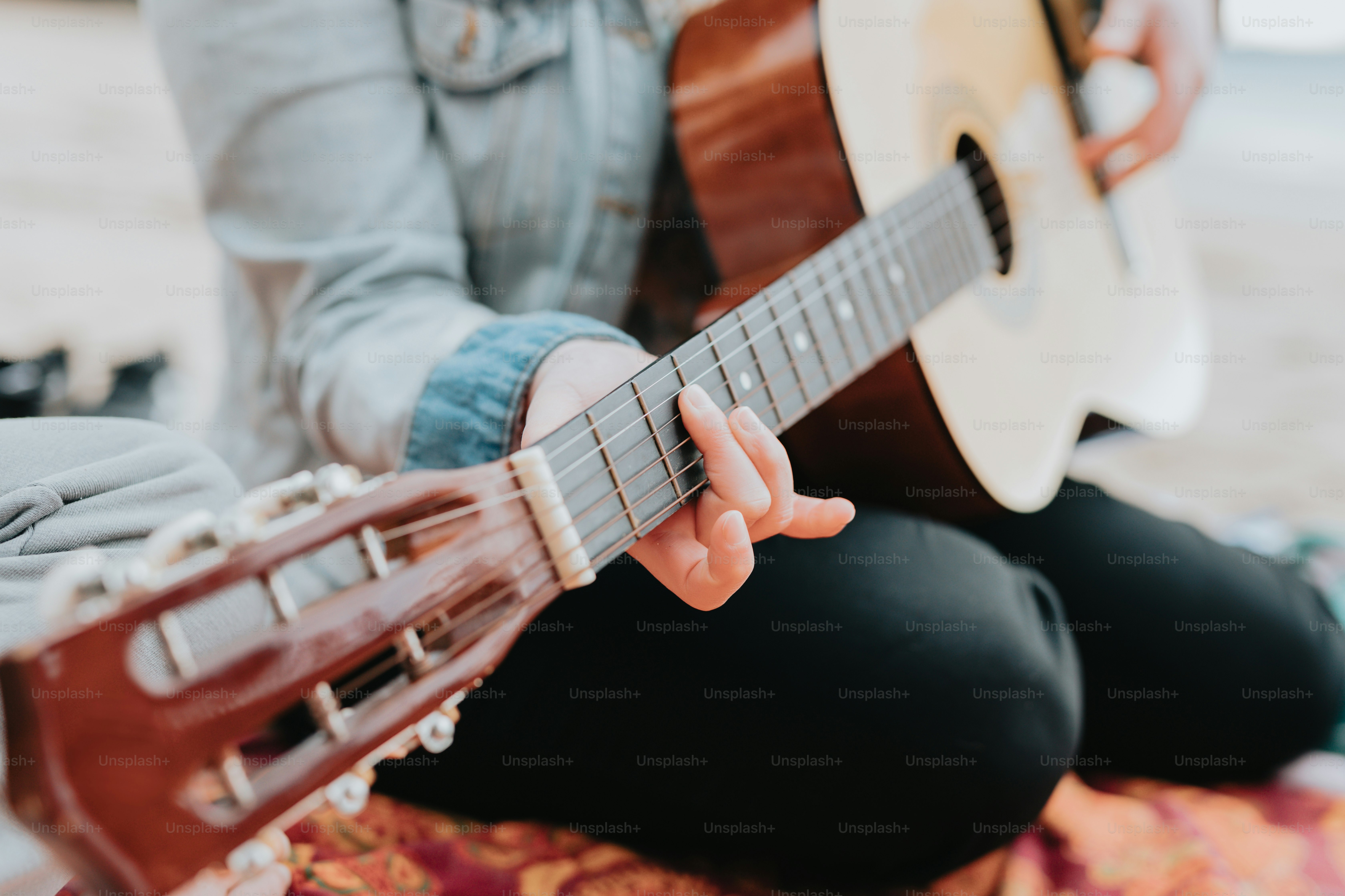 a person sitting on the floor playing a guitar