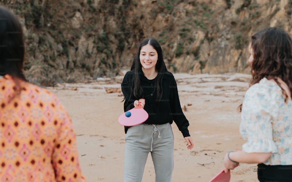 Una mujer sosteniendo un frisbee rosa mientras está de pie junto a otra mujer