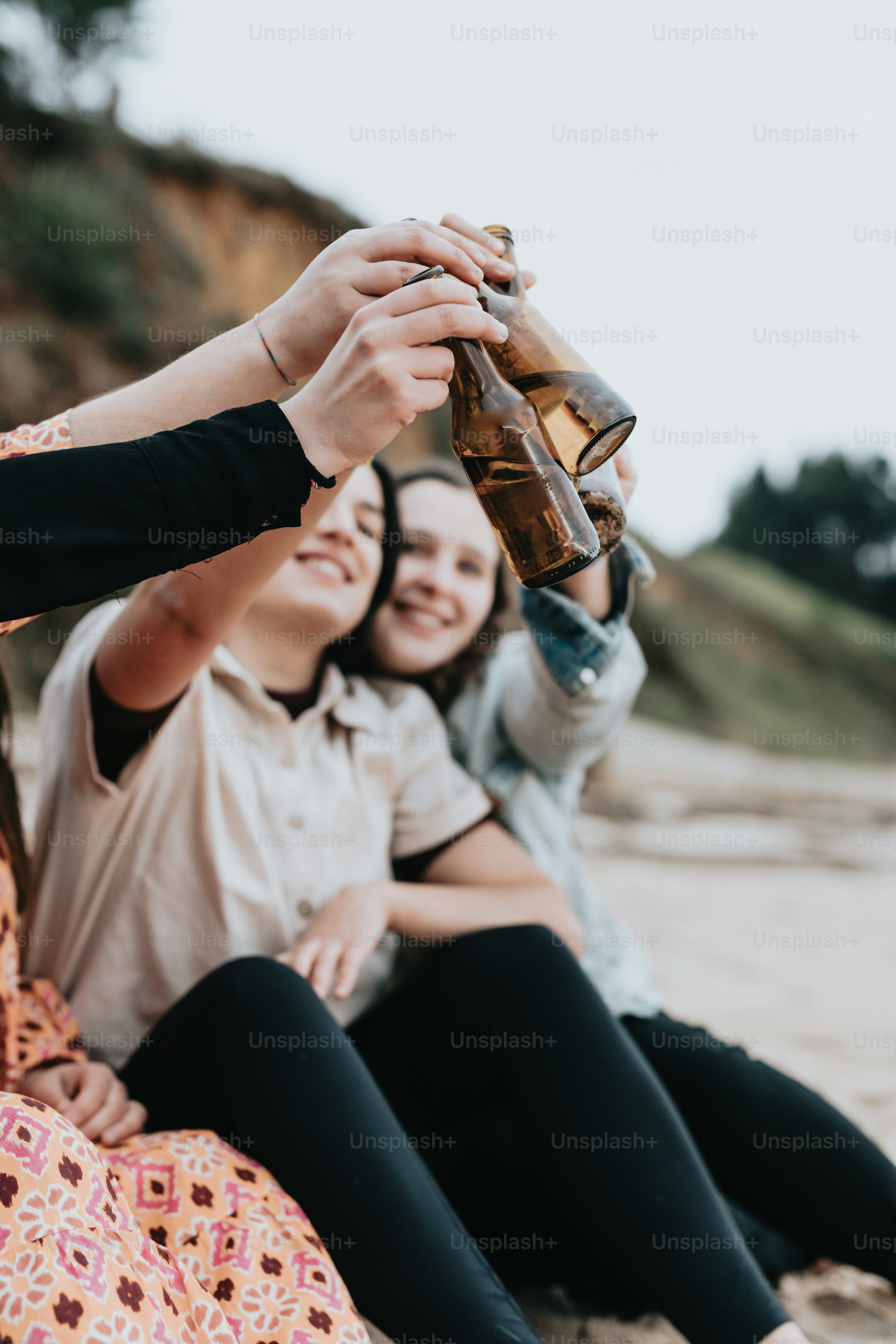 a group of women sitting on top of a sandy beach