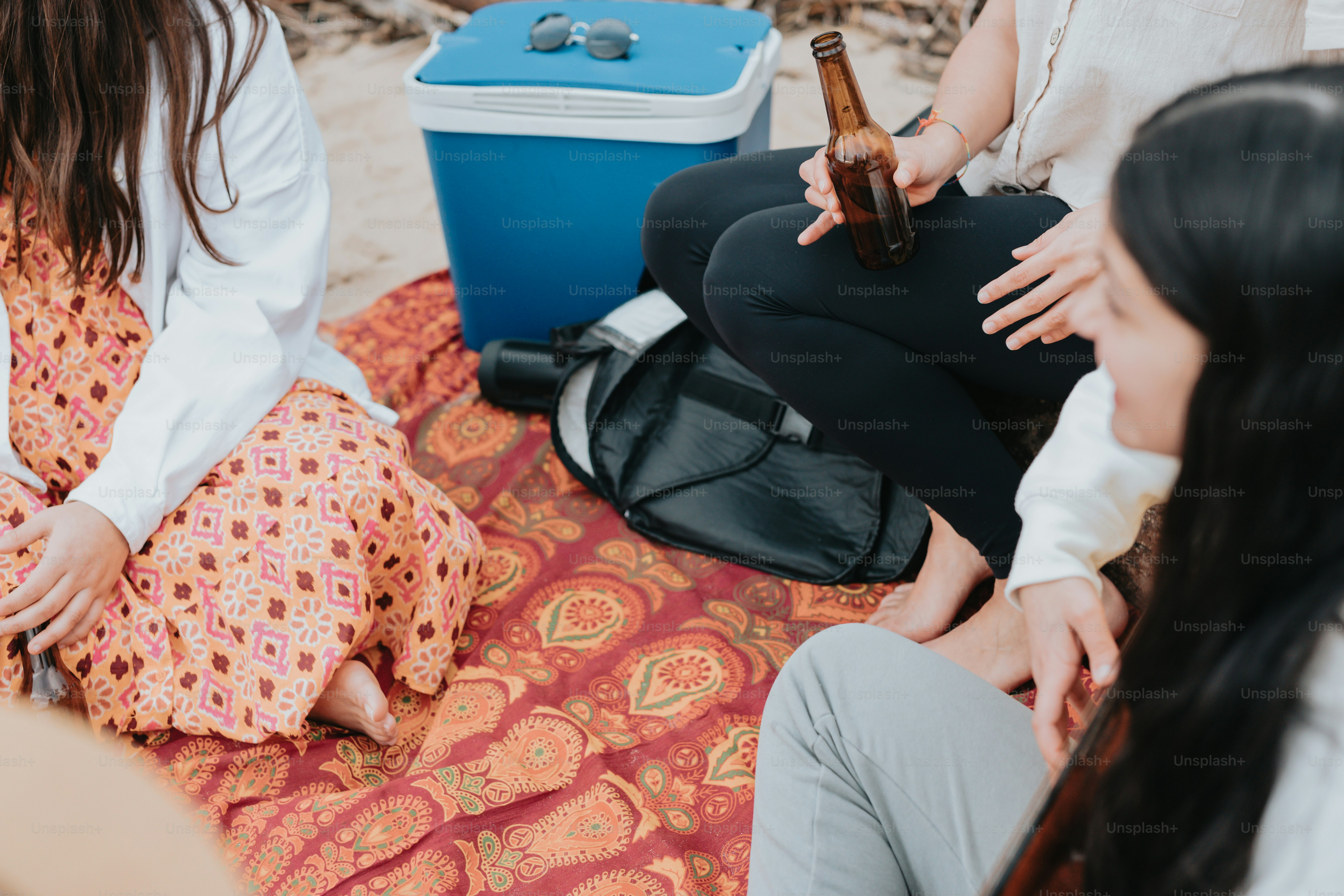 a group of people sitting on top of a blanket
