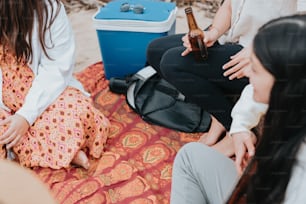 a group of people sitting on top of a blanket