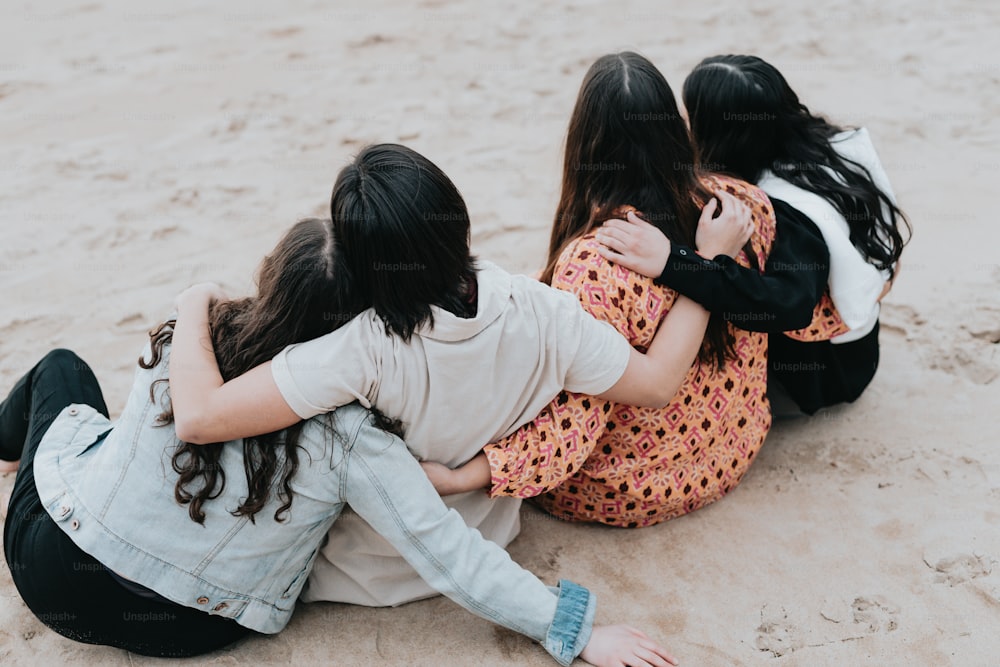 um grupo de meninas sentadas em cima de uma praia de areia
