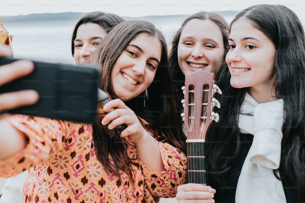 a group of women taking a picture with a cell phone