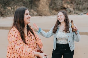 two women standing next to each other on a beach