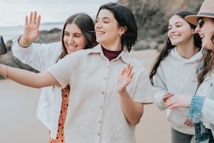 a group of women standing next to each other on a beach