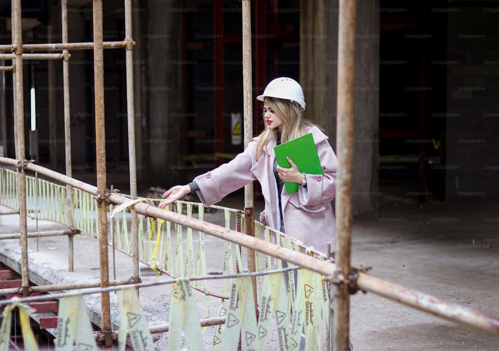 a woman in a hard hat holding a green folder