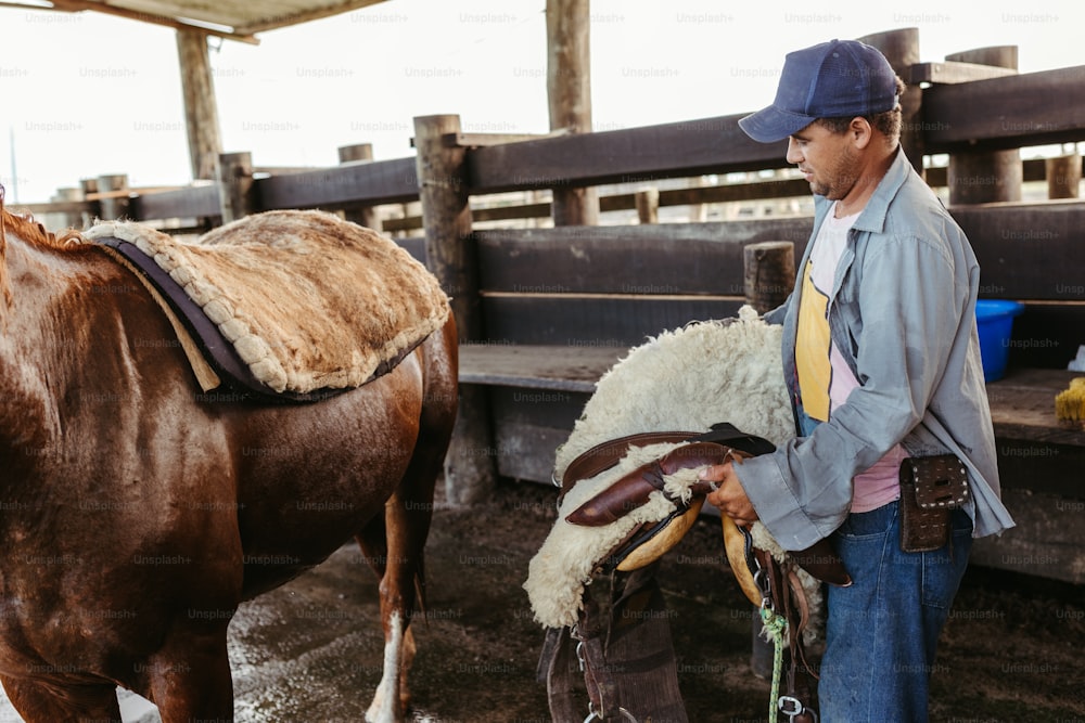 a man standing next to a brown horse