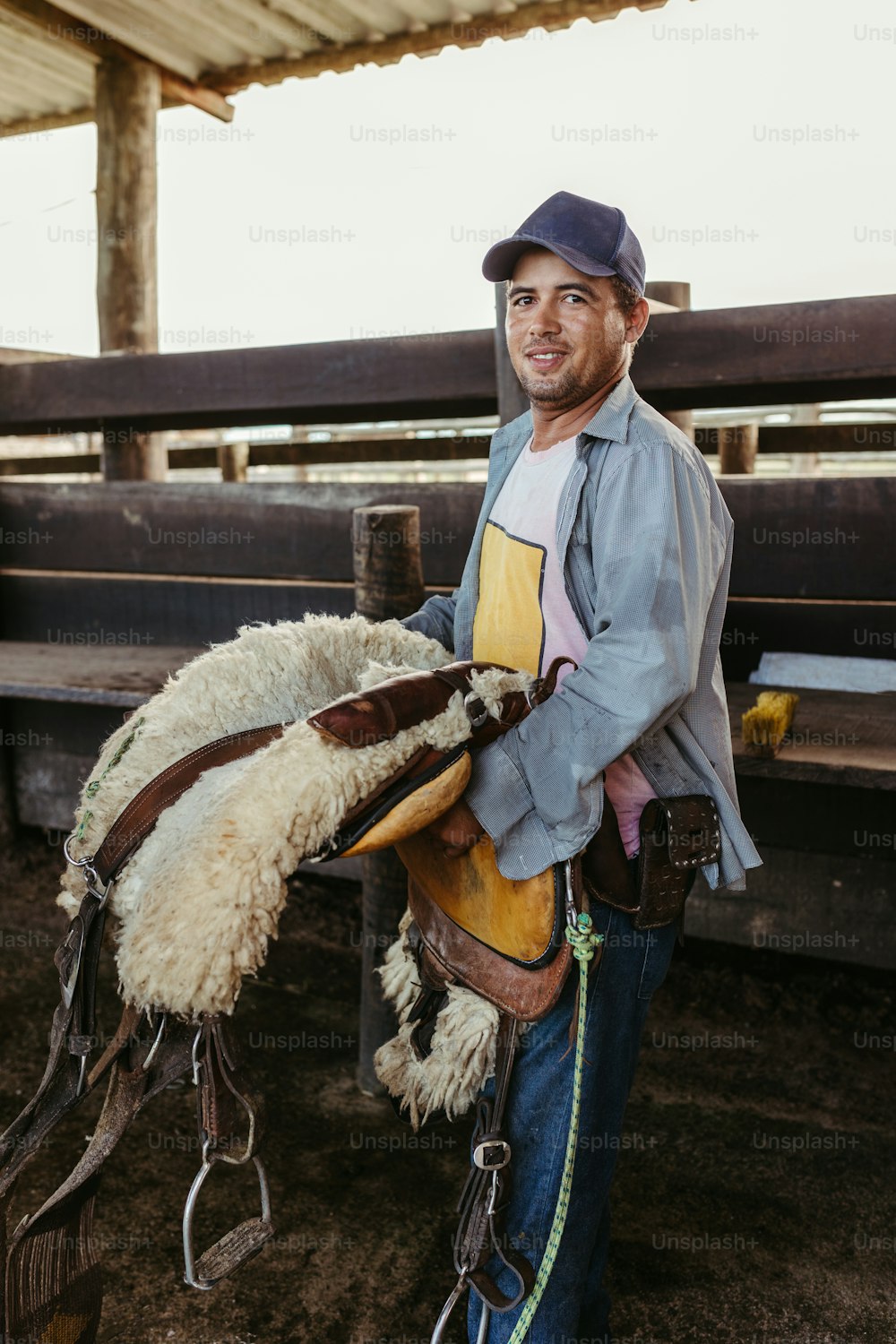 a man is holding a sheep in a corral