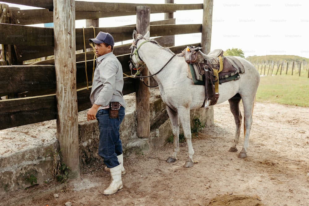 a man standing next to a white horse