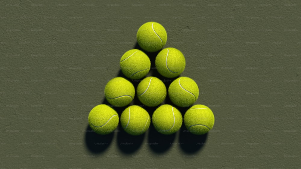 uma pirâmide de bolas de tênis em uma superfície verde