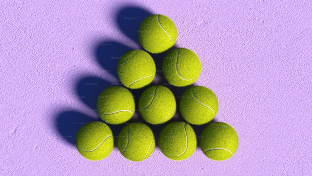 보라색 표면 위에 앉아 있는 테니스 공 더미