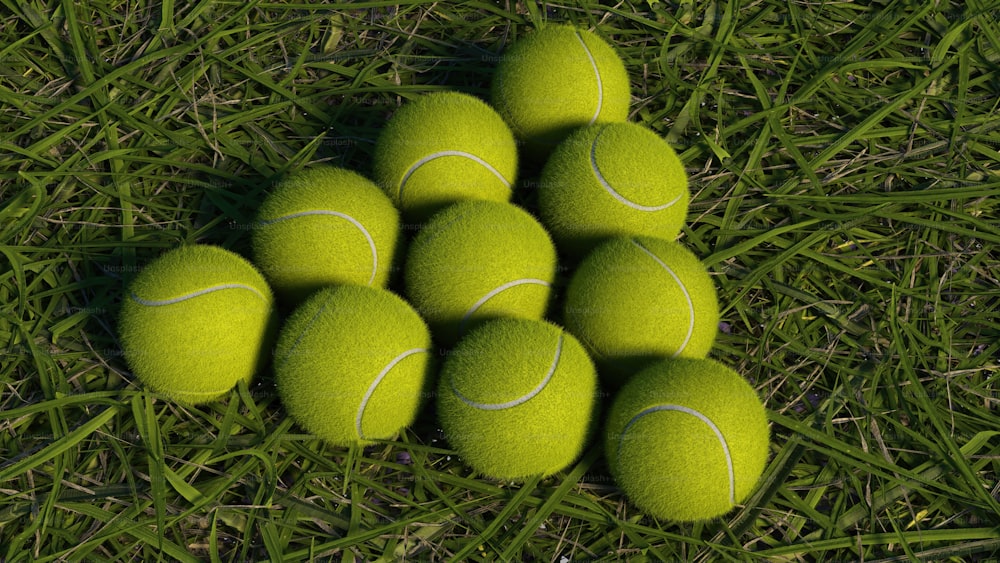 a pile of tennis balls sitting on top of a green field