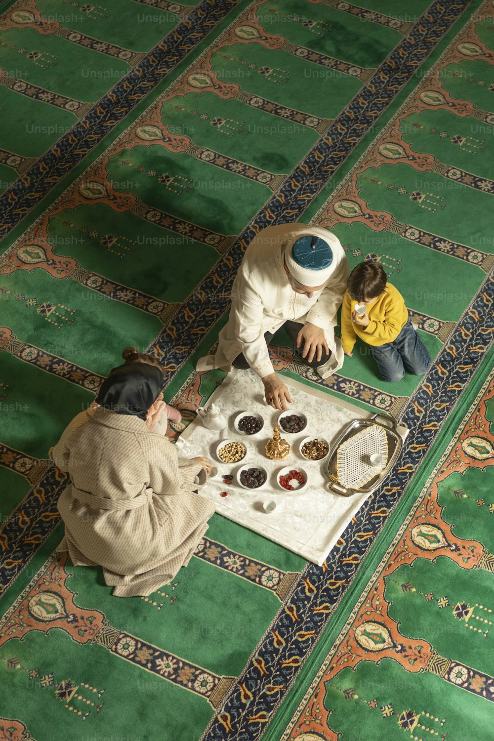 a couple of people sitting on top of a rug