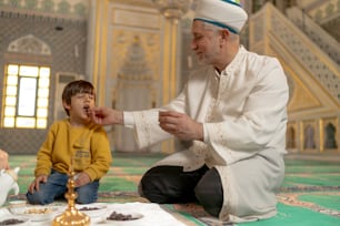 a man kneeling down next to a little boy